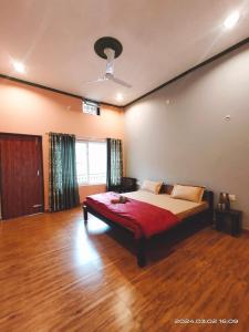 1 dormitorio con 1 cama con manta roja en Gharonda Homestay, en Dogadda