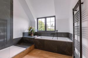 a bathroom with a bath tub and a window at Farmhouse oasis with garden, pond and idyllic surroundings in Beernem