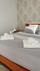 - 2 lits avec des serviettes blanches au-dessus dans l'établissement Casa do Tourão - Ponte de Lima, à Ponte de Lima