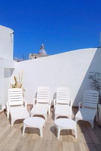 a group of white chairs sitting on a roof at Augusta in Salta