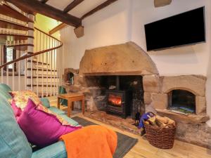 uma sala de estar com uma grande lareira de pedra em Pear Tree Cottage at Hey Farm em Barnoldswick