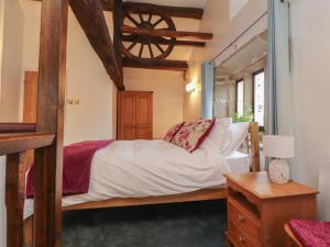 a bedroom with a large bed and a window at Pear Tree Cottage at Hey Farm in Barnoldswick