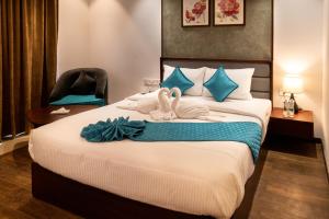 une chambre d'hôtel avec 2 cygnes sur un lit dans l'établissement Gokulam Park Guruvayur, à Guruvāyūr