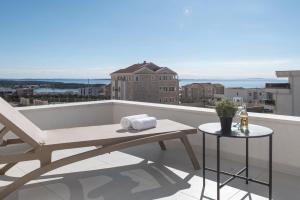 d'un balcon avec un banc et une table sur le toit. dans l'établissement Pool apartments Lux, à Novalja