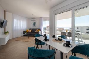 - un salon avec une table et des chaises blanches dans l'établissement Pool apartments Lux, à Novalja