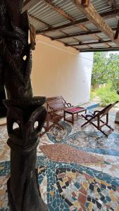 a room with a table and a bench on a mosaic floor at Lodge Jamarek in Kafountine