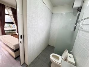 uma casa de banho com um WC, um chuveiro e uma cama. em FAKHIRA RESIDENCE HOTEL em Cianjur