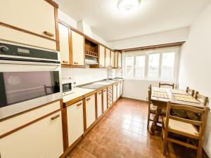 a kitchen with a table and a dining room at Apartamento Cozy by ALÔGA in Cee