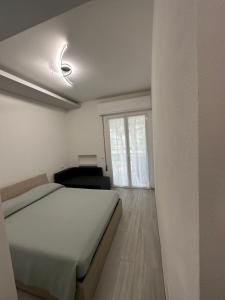 a white bedroom with a bed and a window at Nido azzurro in Cesenatico