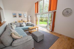 una sala de estar con un sofá y una mesa en Tarka Summerhouse, en Woolacombe