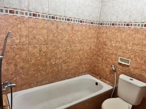 uma casa de banho com banheira e WC em Wisma Atma Bhakti RedPartner near Solo Square em Lawean