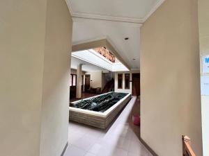 uma vista do corredor de uma casa com uma banheira de hidromassagem em Wisma Atma Bhakti RedPartner near Solo Square em Lawean