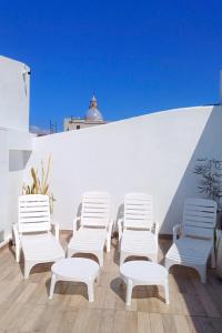 a group of white chairs sitting on a roof at Augusta 8 in Salta