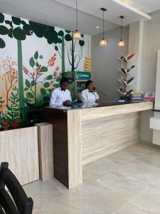 two men sitting at a counter in a restaurant at Greywood Hotel and Apartments in Ikeja