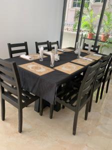 mesa de comedor con mantel negro y sillas en Greywood Hotel and Apartments, en Ikeja