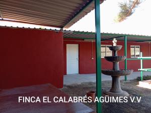 アグイメスにあるLa Cuadra Finca El Calabrésの赤い建物前の噴水