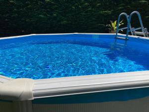 a large blue swimming pool with two chairs in it at RURAL3MIJAROJOS casa con jardin y piscina privada en el centro de Cantabria 