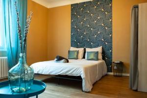 a bedroom with a bed and a vase on a table at Le Bédier in Angers