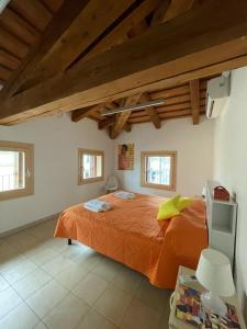 a bedroom with a bed with an orange comforter at Guesthouse Villa Fabris in Thiene
