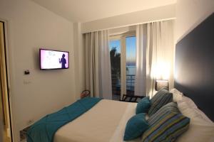 a bedroom with a bed with a tv on the wall at Palma d'Oro in Bagnara Calabra