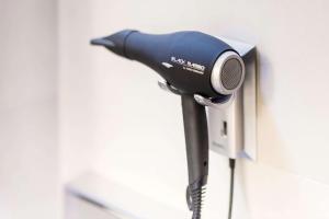 a hair dryer is attached to a wall at NH Amsterdam Noord in Amsterdam