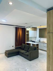 a living room with a couch and a kitchen at Ten heads in Tema