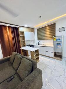 a living room with a couch and a kitchen at Ten heads in Tema