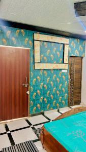 a room with a door and a wall with a peacock wallpaper at Radhey Krishna home stay in Mathura