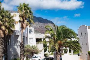 a building with palm trees and a mountain in the background at Heavenly Retreat on Devil's Peak in Cape Town