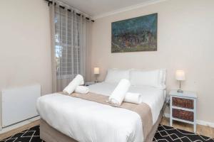 a white bedroom with a large bed with white pillows at Heavenly Retreat on Devil's Peak in Cape Town