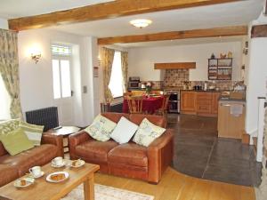 a living room with two couches and a kitchen at Penalltcych Farmhouse Abercych in Abercych