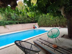 una mesa de picnic y sillas junto a una piscina en Chambre double avec piscine 15 mn du Cap d'Agde, en Saint-Thibéry