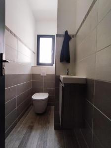 baño con aseo y lavabo y ventana en Chambre double avec piscine 15 mn du Cap d'Agde, en Saint-Thibéry