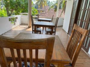 Una mesa y sillas de madera en un balcón. en New Bimal Villa, en Bentota 36 fotos más