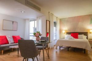 una camera con letto, divano e tavolo di Edificio Leganitos a Madrid