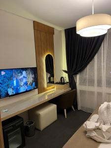 Habitación de hotel con escritorio y TV. en Mahall Hotel, en Estambul