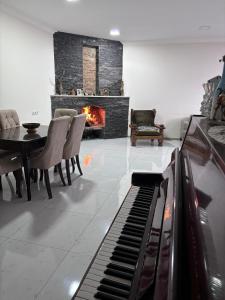 a living room with a piano and a fireplace at Friendly House in Akhaltsikhe