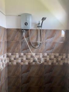 y baño con ducha y suelo de baldosa. en New Bimal Villa, en Bentota