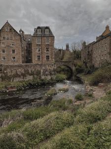 a river in a city with a bridge and buildings at Loggia Studio in Edinburgh
