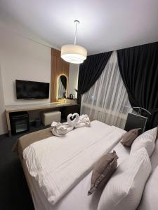 een slaapkamer met een groot wit bed en een televisie bij Mahall Hotel in Istanbul