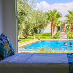 una vista de una piscina con gente en ella en Hotel Jnane riad, en Marrakech