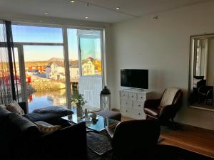 un salon avec un canapé, des fauteuils et une télévision dans l'établissement Svolvær Havn Apartments, à Svolvær
