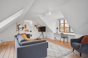 uma sala de estar com um sofá e duas cadeiras em Come Stay - Stilfuld Elegance for 4 med pejs em Aarhus