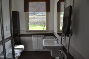 a bathroom with a sink and a toilet and a window at Dolce Casa Lago in Paratico