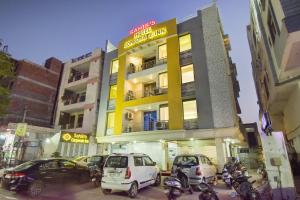 a building with cars parked in front of it at Hotel Sahibs Corporate Inn - The Family Hotel in Jaipur