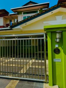 a green gate in front of a house at HmAirbnb@Two in Sibu