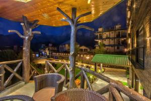 een balkon met stoelen en een muurschildering van bomen bij Hotel Katson Castle Dharamshala in McLeod Ganj