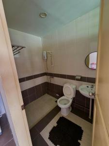y baño con aseo y lavamanos. en HmAirbnb@Two en Sibu