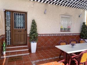 un patio con puerta, mesa y sillas en Casa encantadora y confortable en Málaga., en Málaga