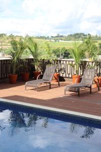 a couple of chairs sitting next to a swimming pool at Pouso Mineiro in São João Batista do Glória